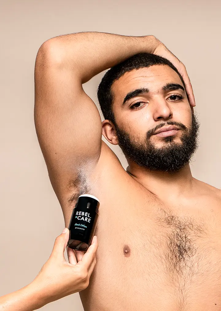 Man with beard applying deodorant