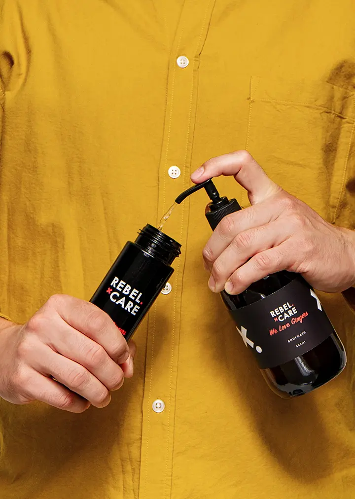 Man holding and showing how to refill Rebel care we love gingers body care refill
