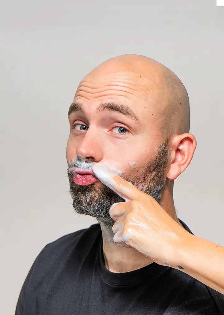 Finger applying Rebel care face wash minty mornings to mans beard
